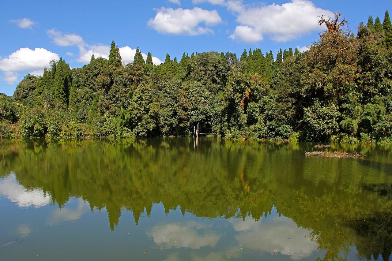 Mai Pokhari lake reflecting the surrounding forest