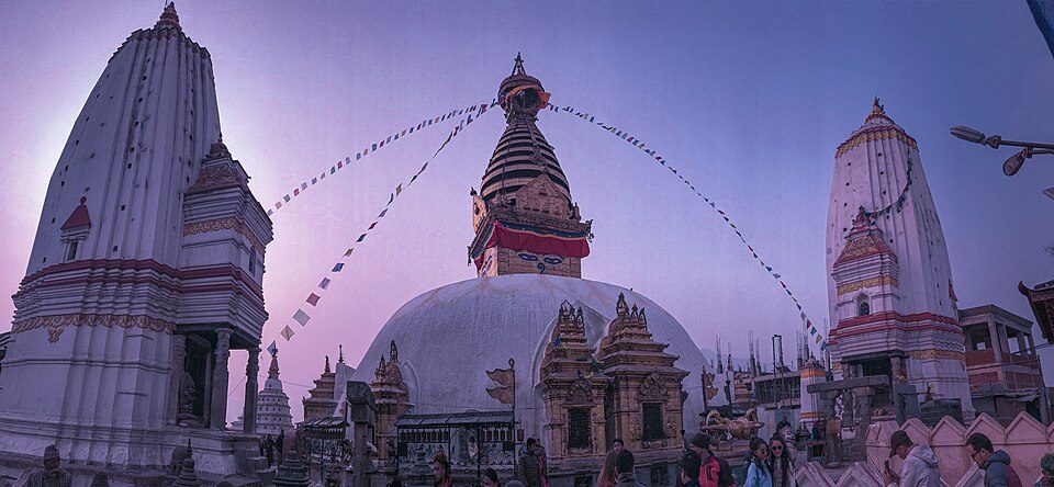 The stupa, shrines and prayer flags of Swayambhunath at dusk